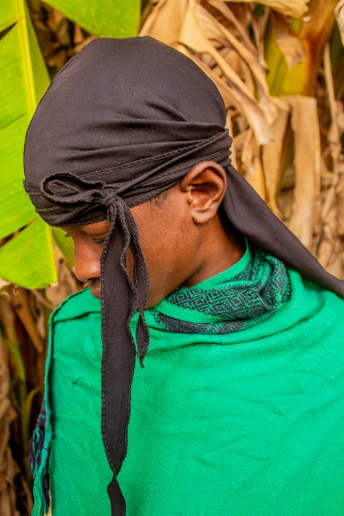 A young african man wearing a head scarf