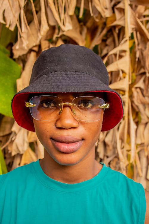 A young man wearing glasses and a hat