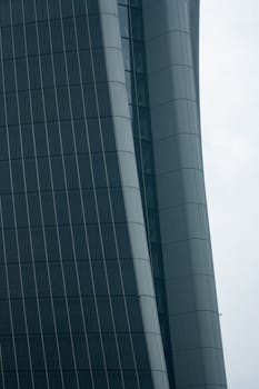 这是一张米兰现代摩天大楼玻璃立面的特写视图，展现了其创新设计