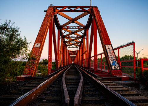 Free A colorful railway bridge in Pedro Meoqui, Mexico, captured during sunset. Stock Photo