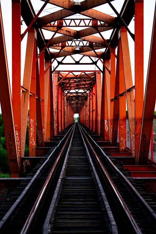 Free Symmetrical view of a red railway bridge in Pedro Meoqui, Mexico, showcasing vibrant steel structures. Stock Photo