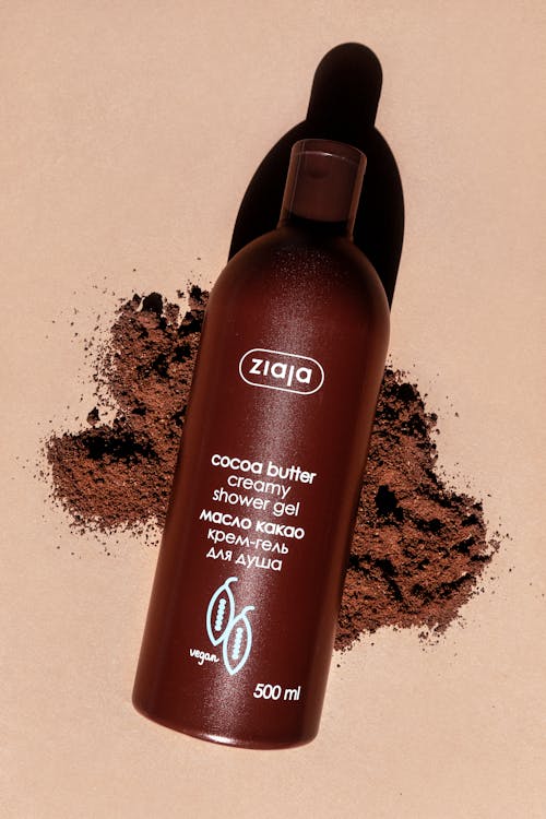 A bottle of chocolate body wash on a brown surface
