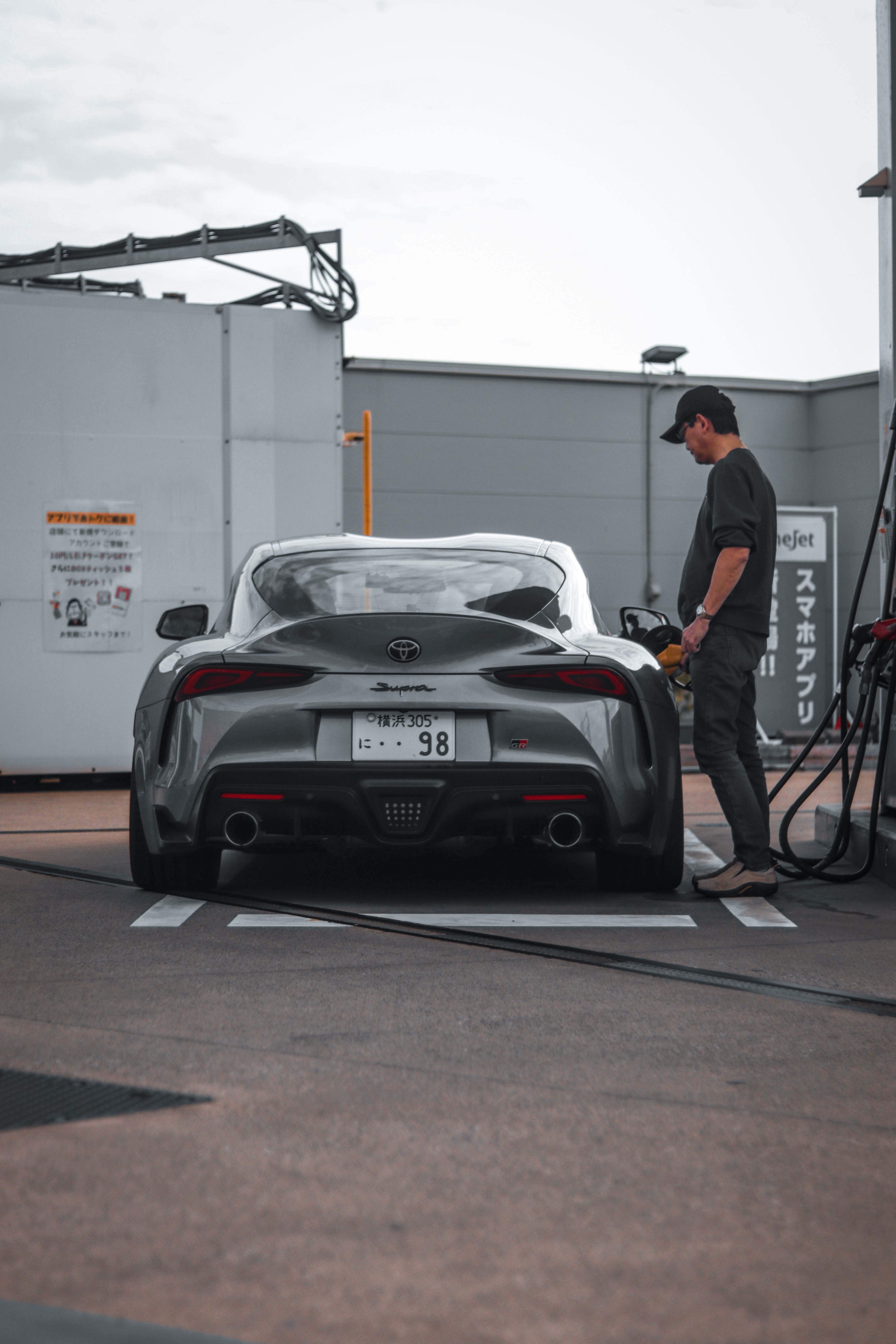 A man is filling up his car at a gas station · Free Stock Photo