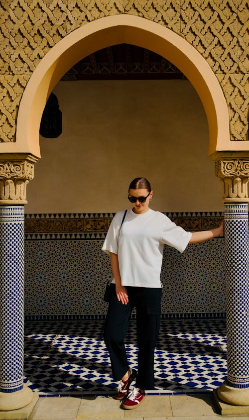 A woman standing in front of an archway