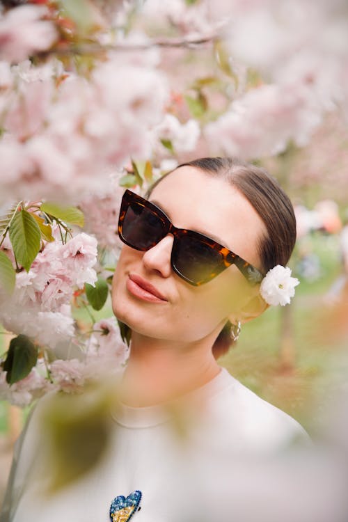 A woman wearing sunglasses and a flower in her hair