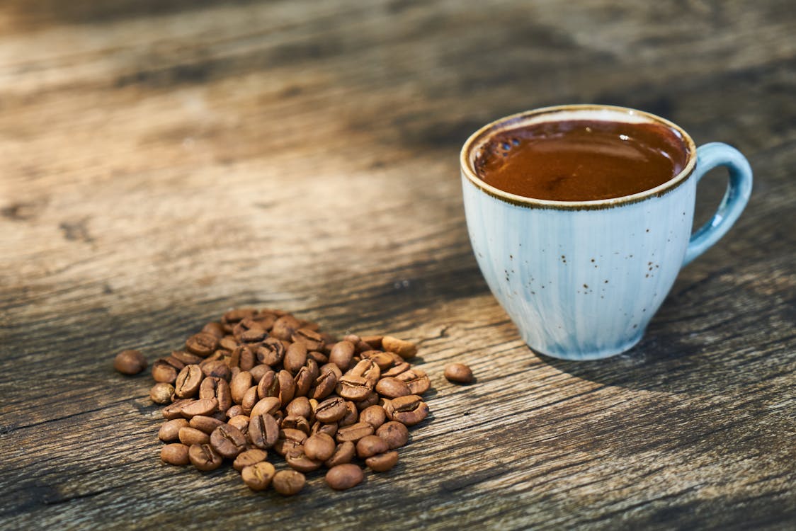 Free Cup Of Coffee Beside Coffee Beans Stock Photo