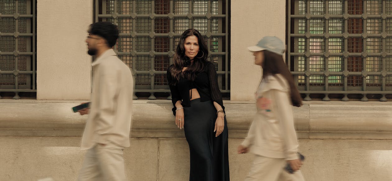 A woman in a black dress and skirt walking down the street