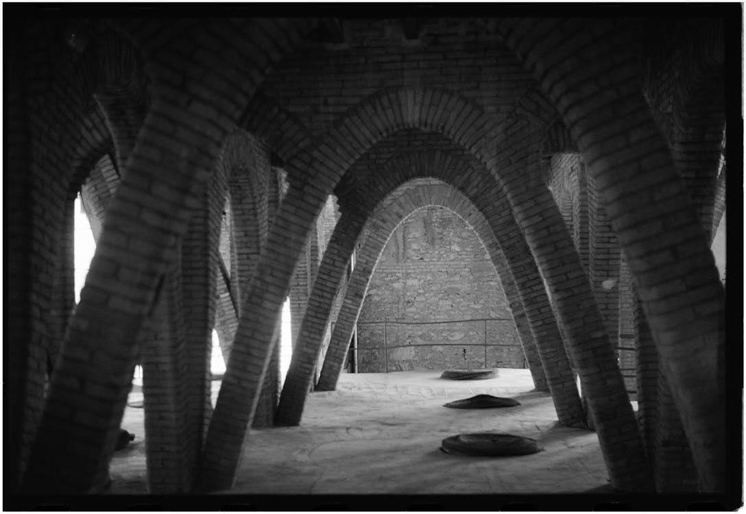 A black and white photo of a building with arches