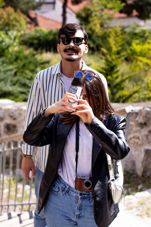 A man and woman taking a selfie with their cell phones