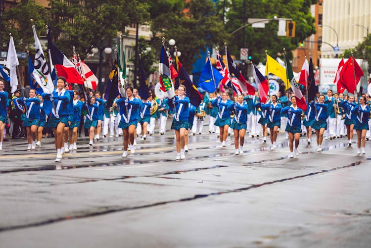 Women Wearing Blue Dress Parade Near Trees