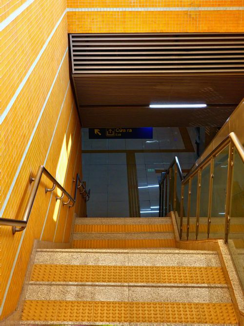 Free Bright yellow tiled staircase leading to Hanoi's modern subway station. Stock Photo