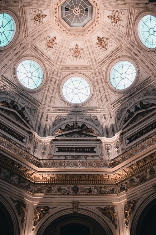 The ceiling of a building with a dome and windows
