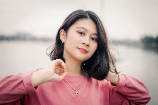 河边，一位穿着粉色毛衣的女子肖像散发着优雅和自信