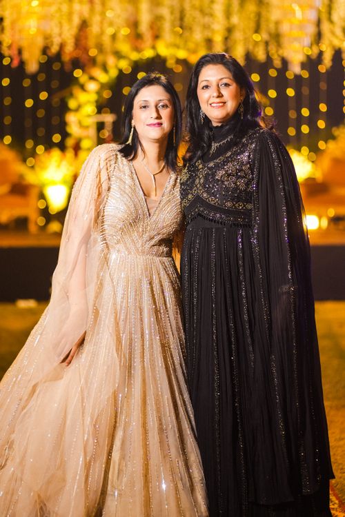 Free Two women in glamorous evening dresses posing at a vibrant celebration with lights. Stock Photo