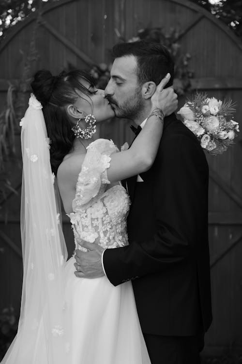 Black and white photo of bride and groom kissing