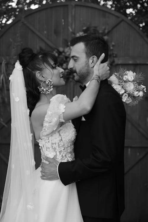 Black and white photo of bride and groom kissing