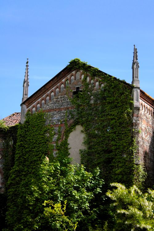 Free A historic ivy-covered church facade set against a clear blue sky in Merate, Italy. Stock Photo