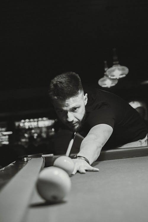 young guy hits a billiard ball (black and white vibe)