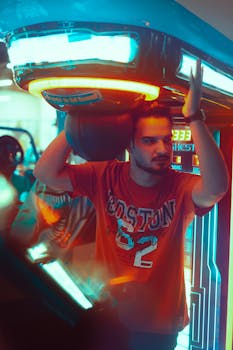 Young man enjoying an arcade basketball game in a vibrant indoor setting in Baghdad.