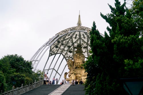 A large golden statue is sitting on top of a hill