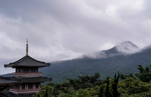 A pagoda in the mountains with clouds and trees