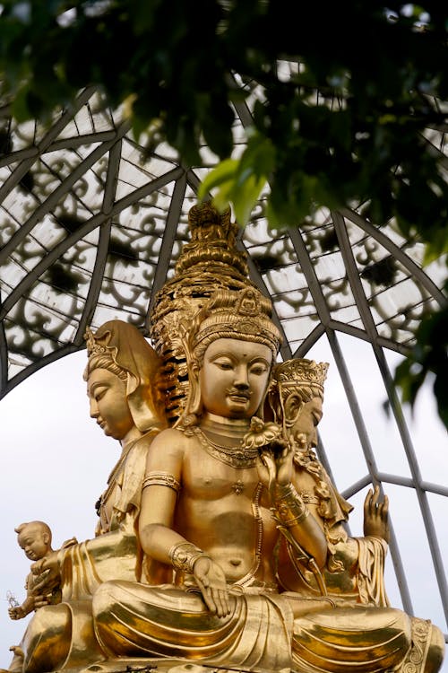A golden statue of buddha in a gilded cage