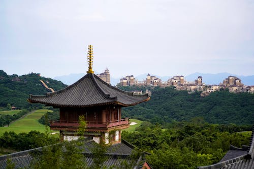 A pagoda sits on top of a hill overlooking a city
