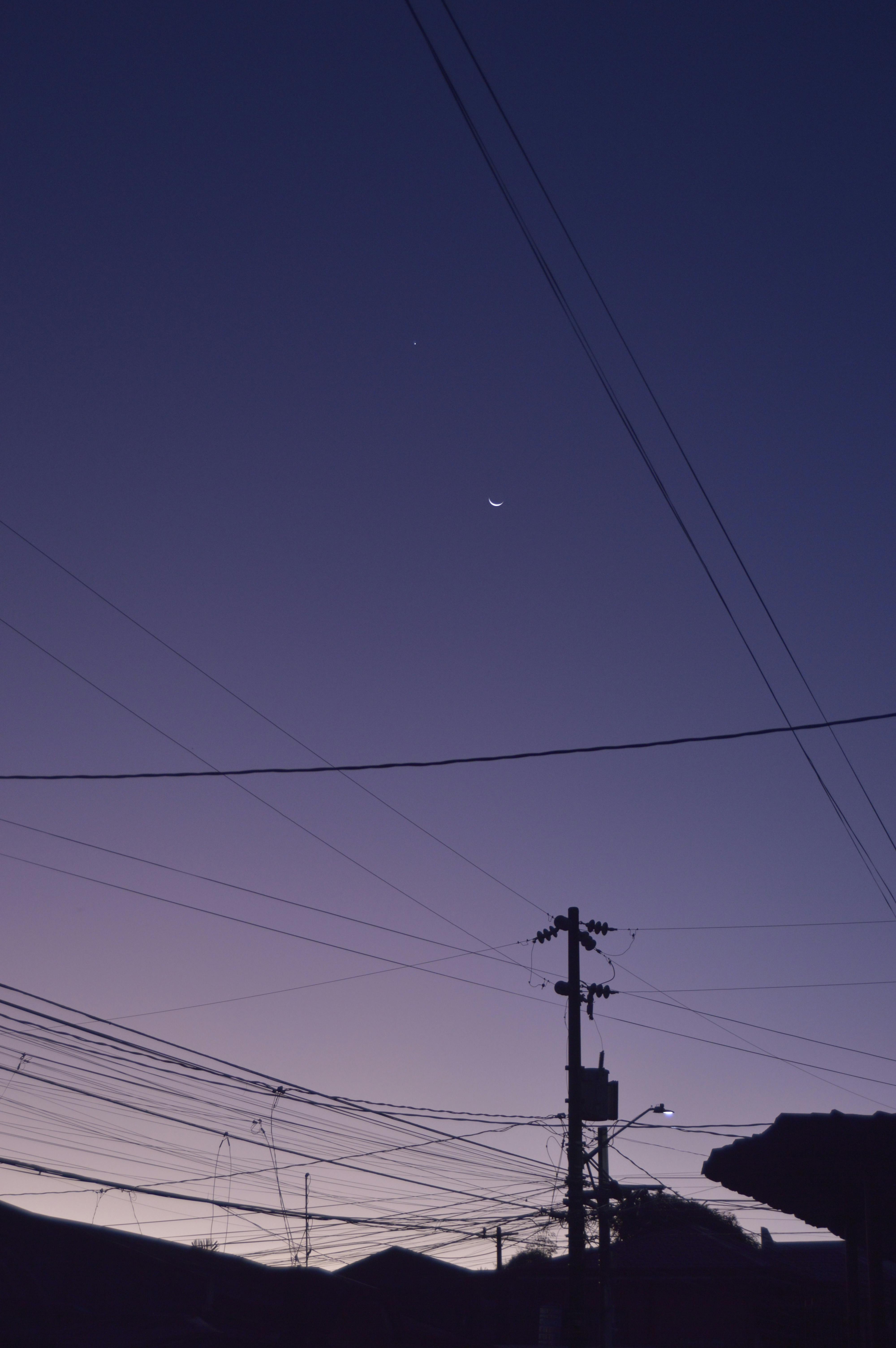 silhouetted buildings and power lines at dusk