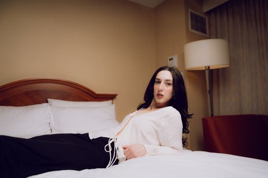 A woman laying on a bed in a hotel room