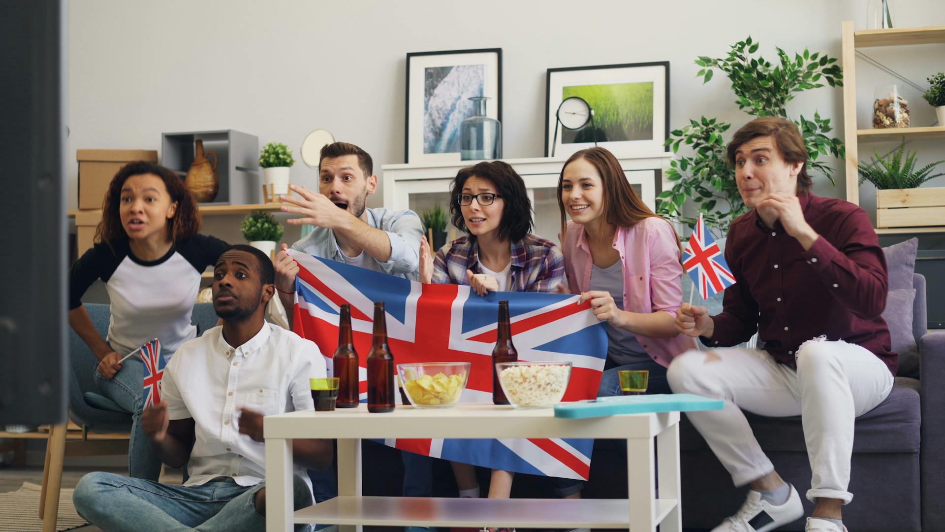 Men and Women with British Flag Watching TV