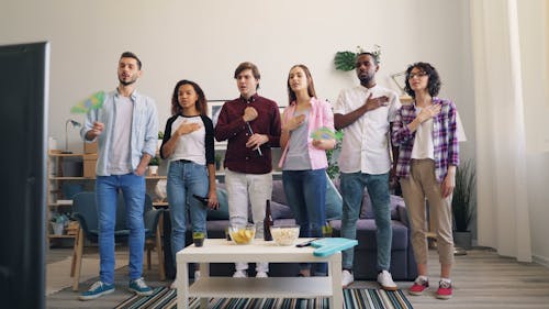 Group of friends watching tv in living room
