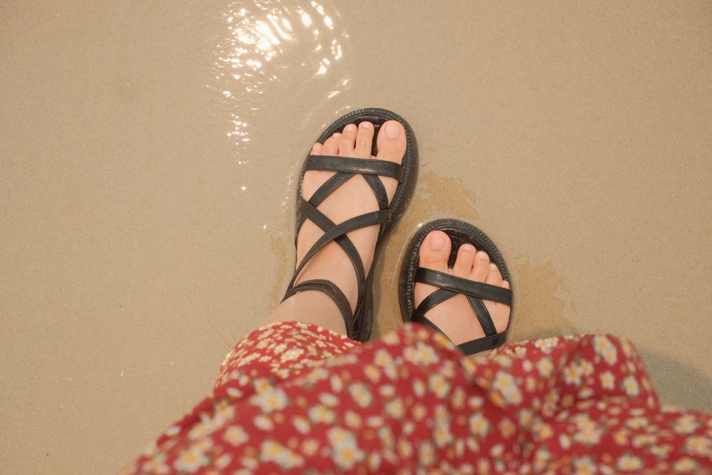 Feet in sandals on sand