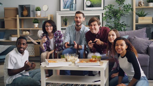 Free A group of people sitting on a couch playing video games Stock Photo