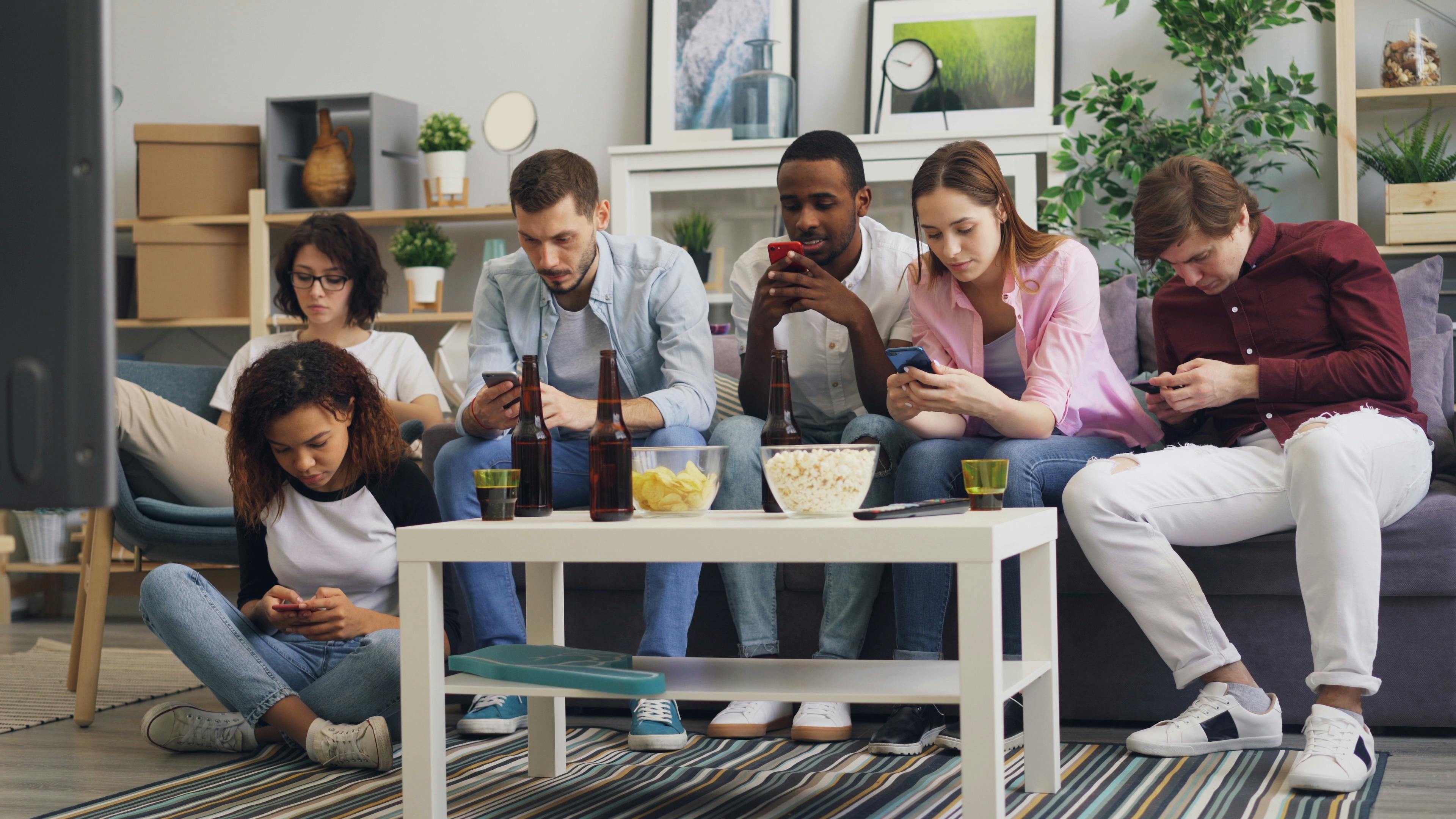 a group of people sitting on a couch watching tv