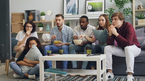 Group of people sitting on couch watching tv