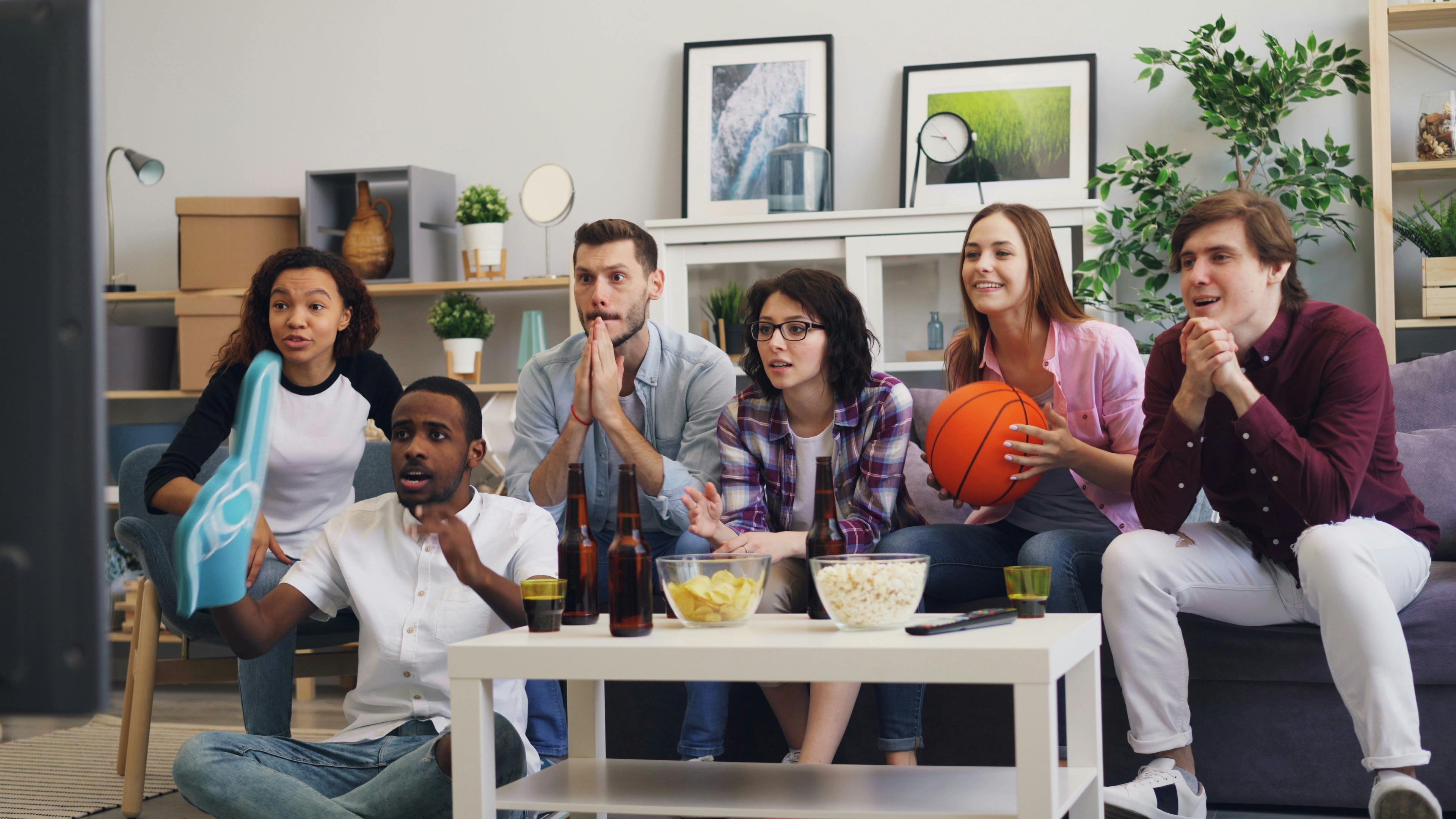 group of friends watching tv in living room