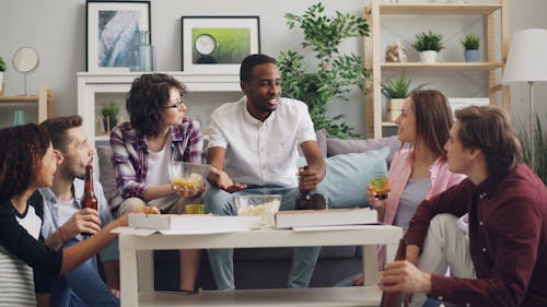 A group of people sitting around a table in a living room