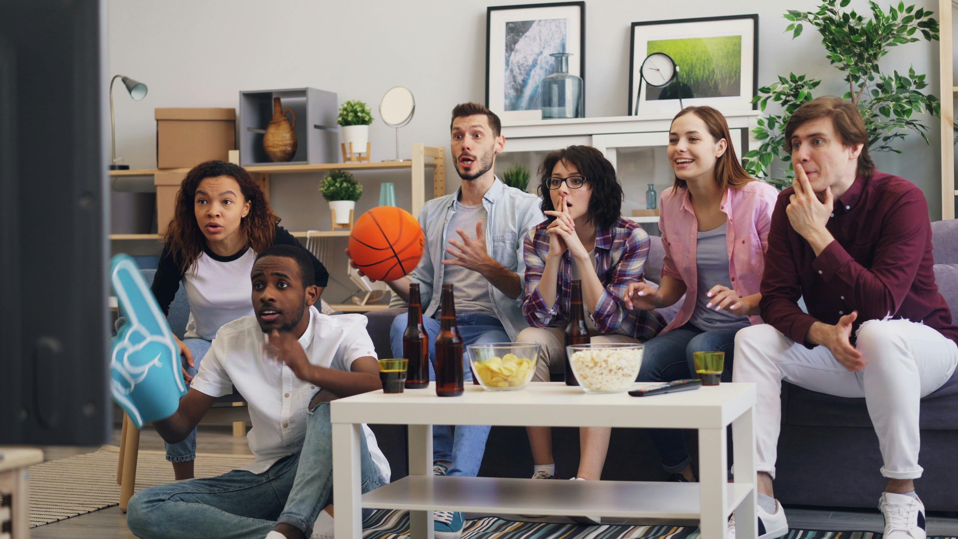 group of friends watching tv in living room