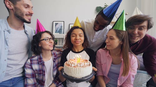 A group of people celebrating a birthday with a cake