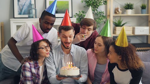 Group of friends celebrating birthday with cake