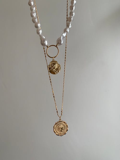 A necklace with a gold coin and pearl