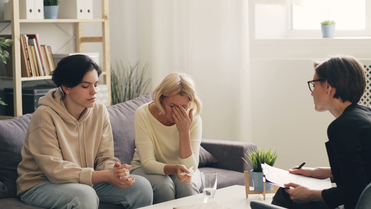 Emotional family therapy session with a therapist indoors, conveying connection and support