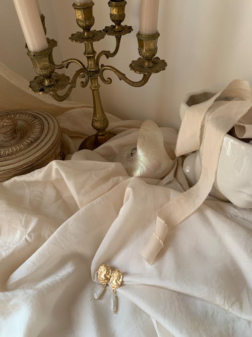 A white cloth with a candle and a gold ring