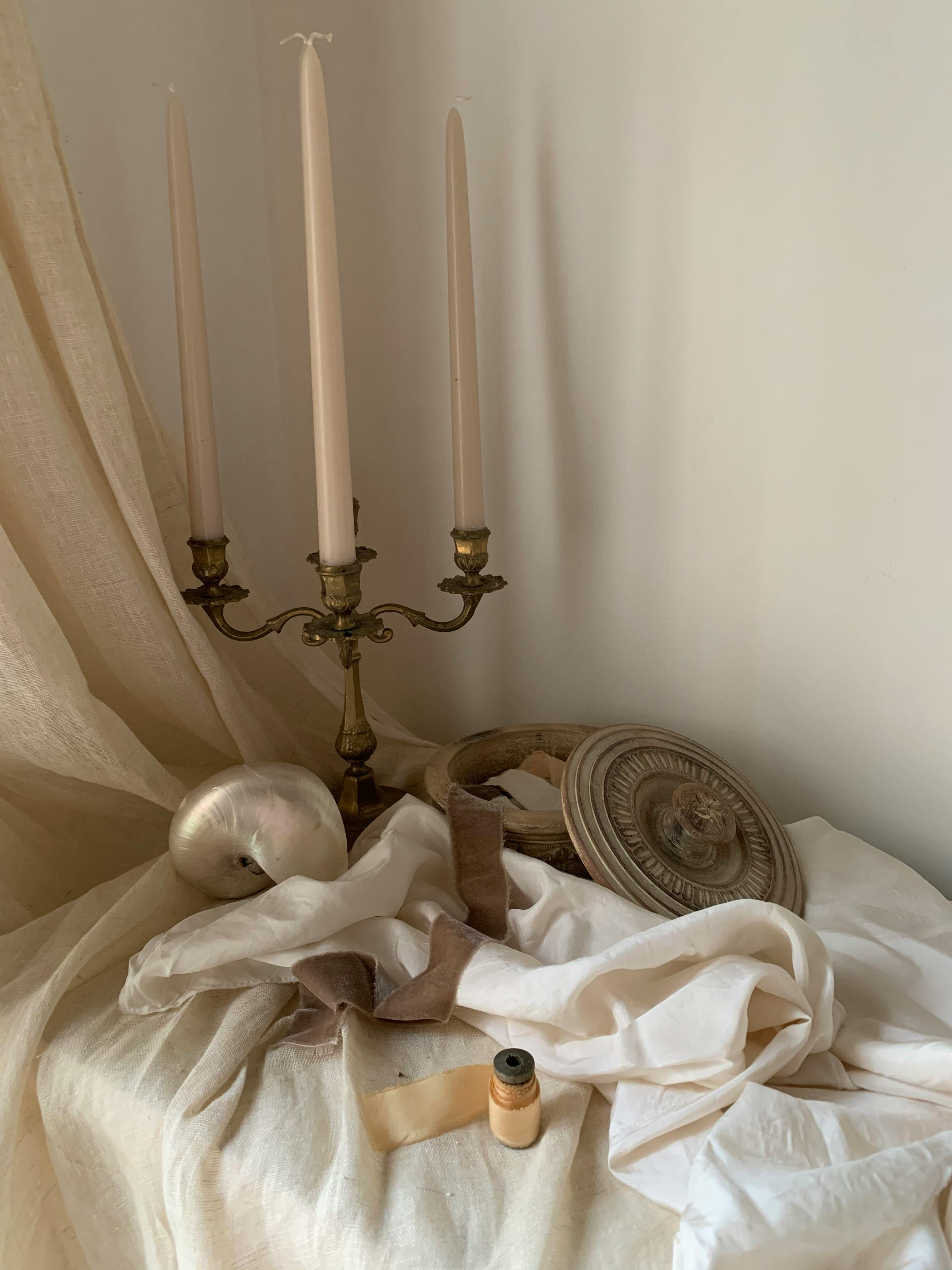 Intricate still life in Paris featuring a candlestick and draped fabric.