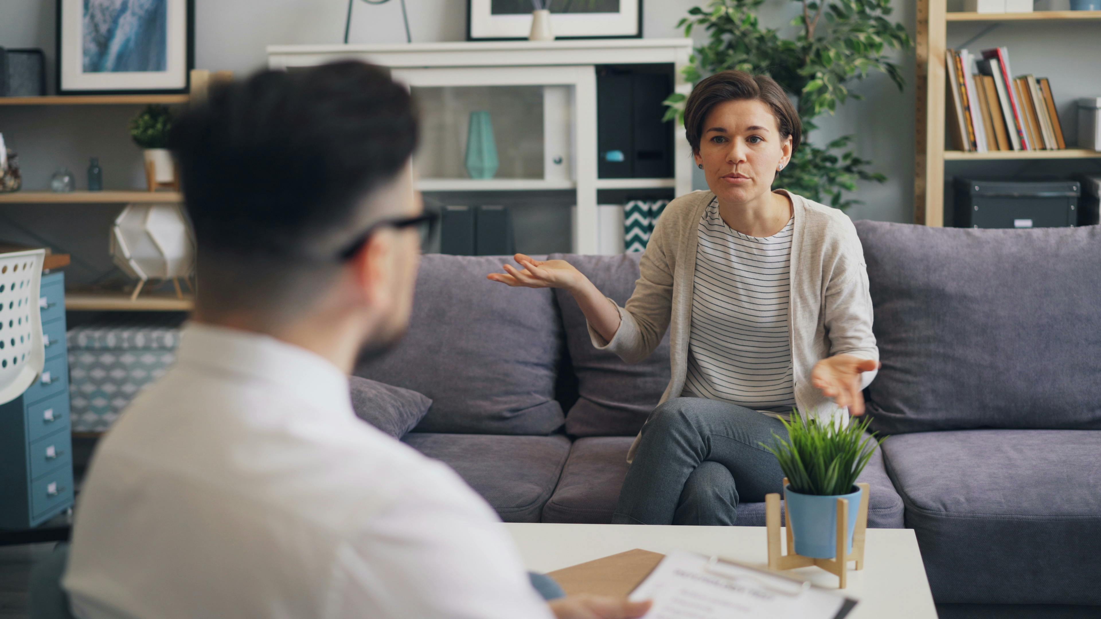 A woman consulting with a professional therapist in a modern office setting. 