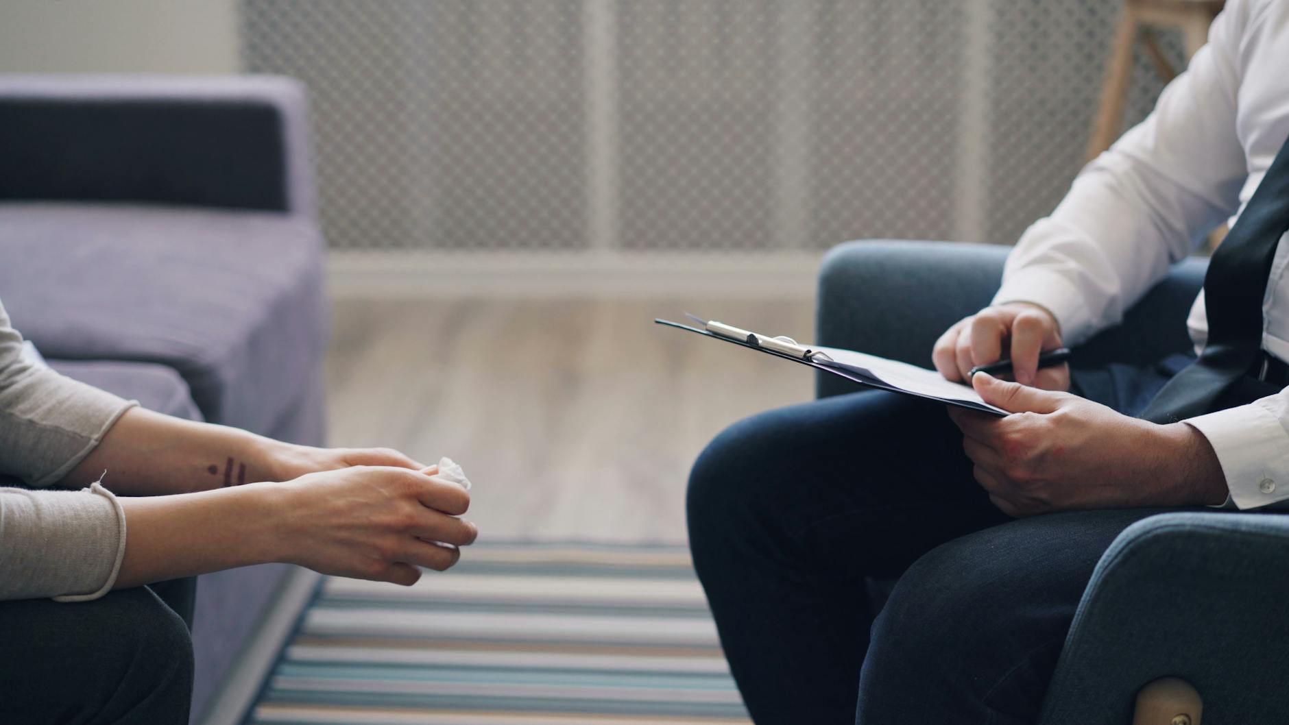 A man and woman sitting in a chair talking to each other