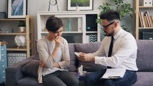 A man and woman sitting on a couch talking