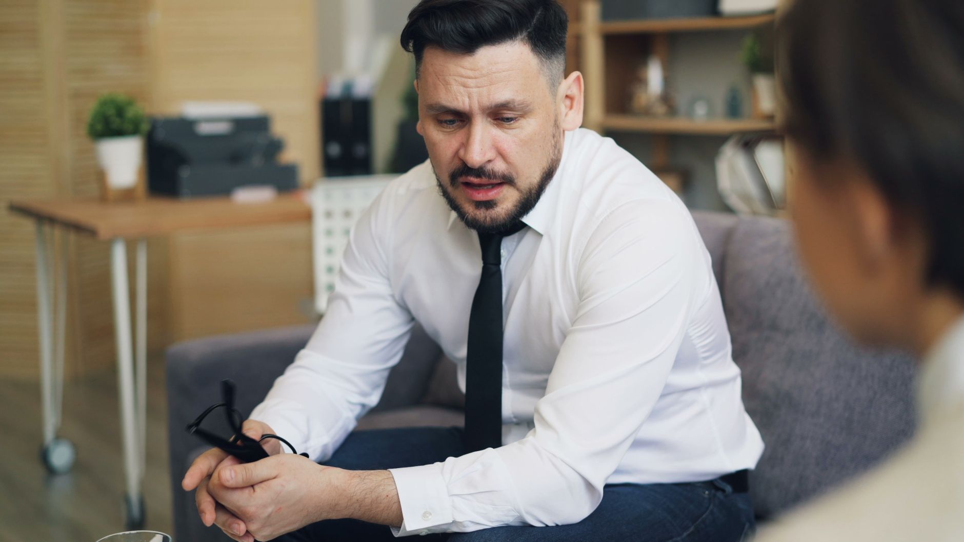 Psychotherapist in conversation with client, addressing emotional concerns in a calm office setting.