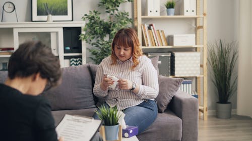 A woman and a man sitting on a couch talking