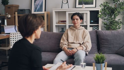 Free Teen undergoing therapy in modern office, showcasing supportive dialogue. Stock Photo